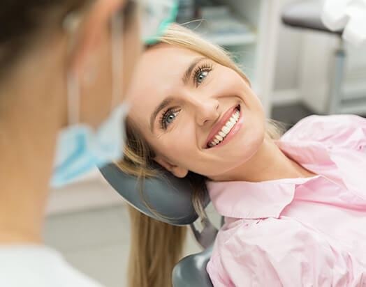 smiling woman talking with her dentist