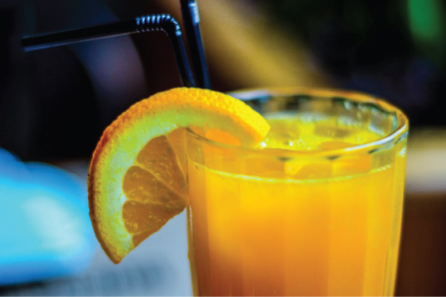 glass of orange juice with an orange wedge on the rim